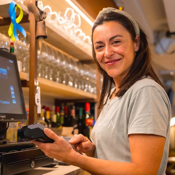 Waitress taking a contactless card payment on a countertop terminal