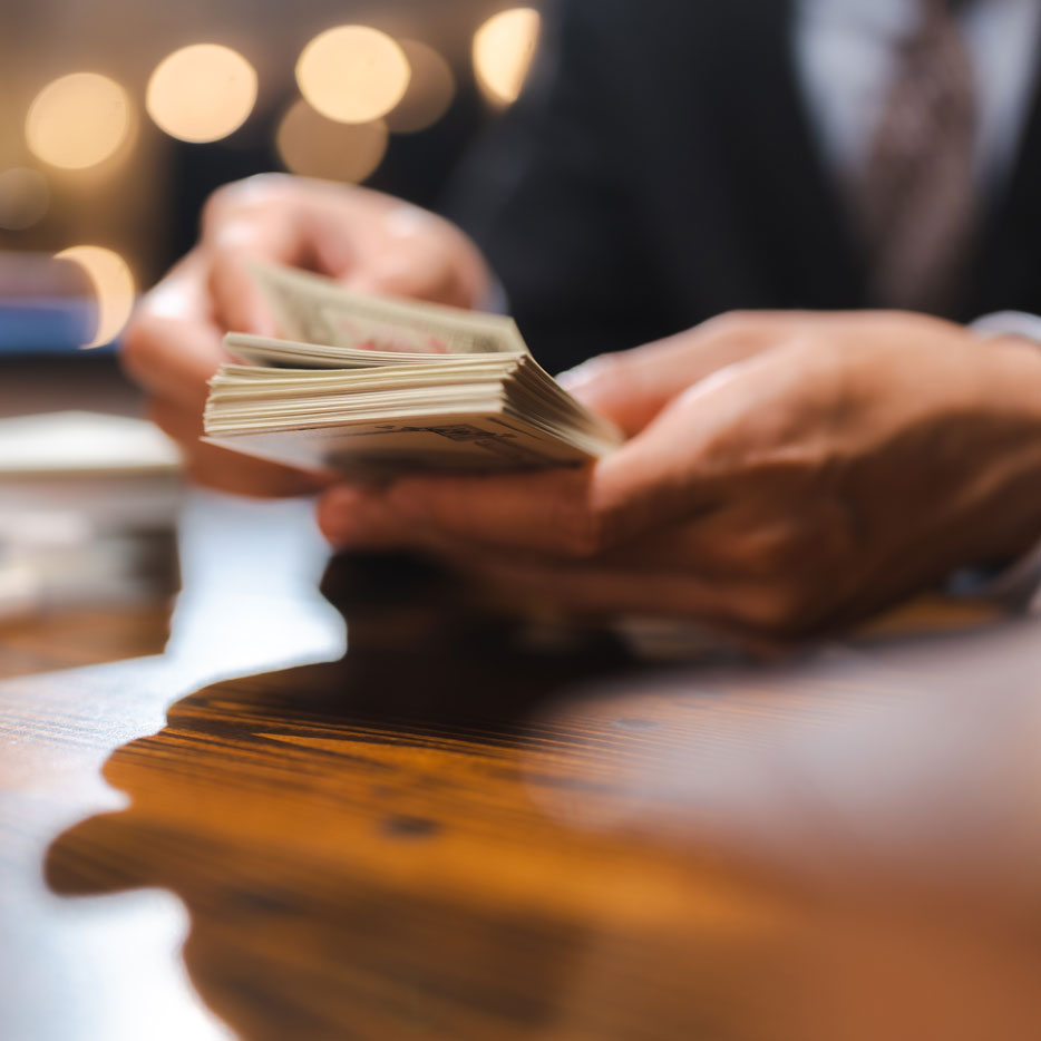 Business owner counting cash at a desk after receiving next day funding