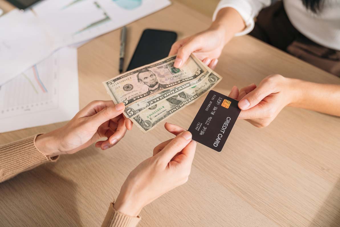 Customer choosing between paying with cash or a credit card at the counter