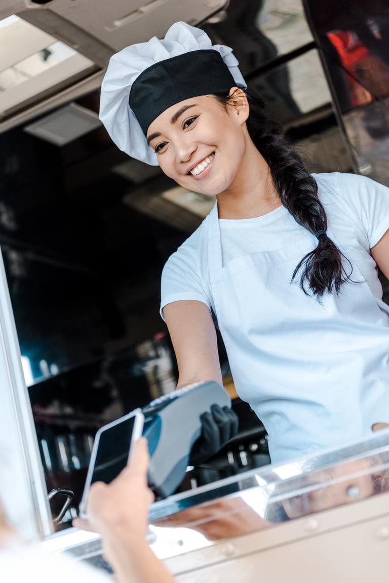 Restaurant guest paying a bill with a smartphone at a countertop card reader